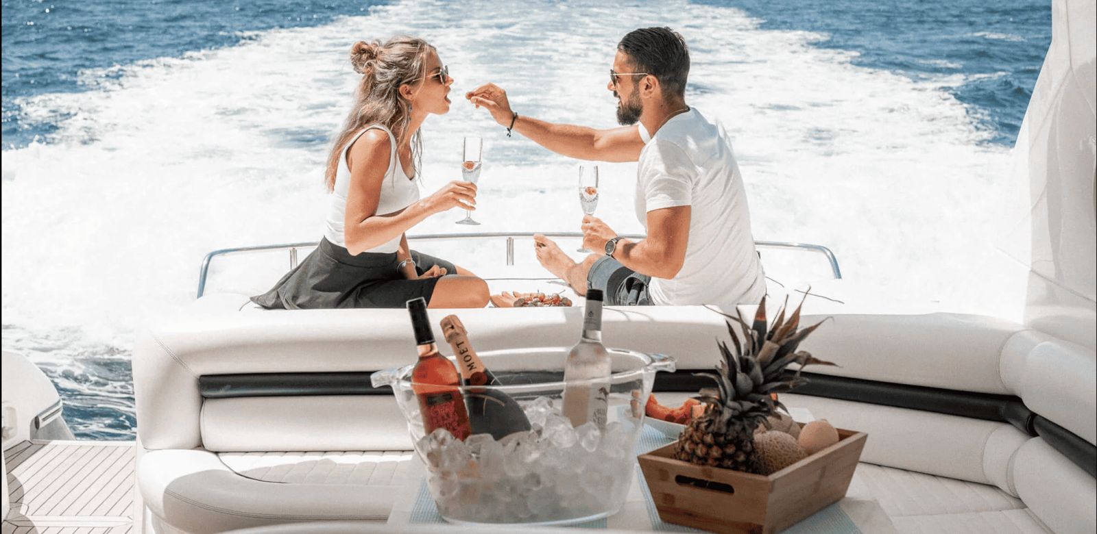 Couple enjoying a romantic champagne moment on a luxury yacht in Lebanon, surrounded by blue waters and sunshine with a view of the open sea.